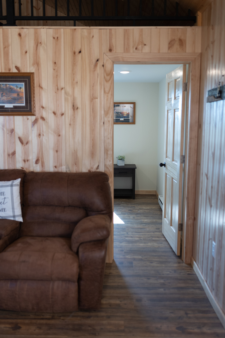 Restful Refuge cabin couch and door to bedroom by Devils Lake, North Dakota